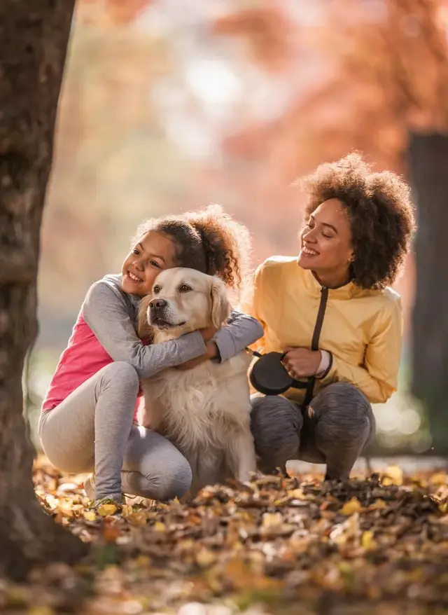 Mom and daughter kneeling while hugging a dog.